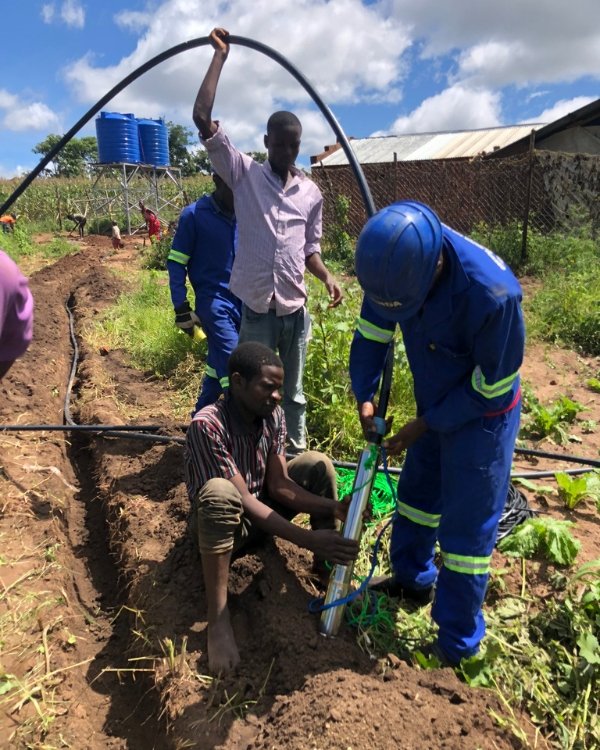 Community in Malawi installing a solar powered pump for their irrigation system